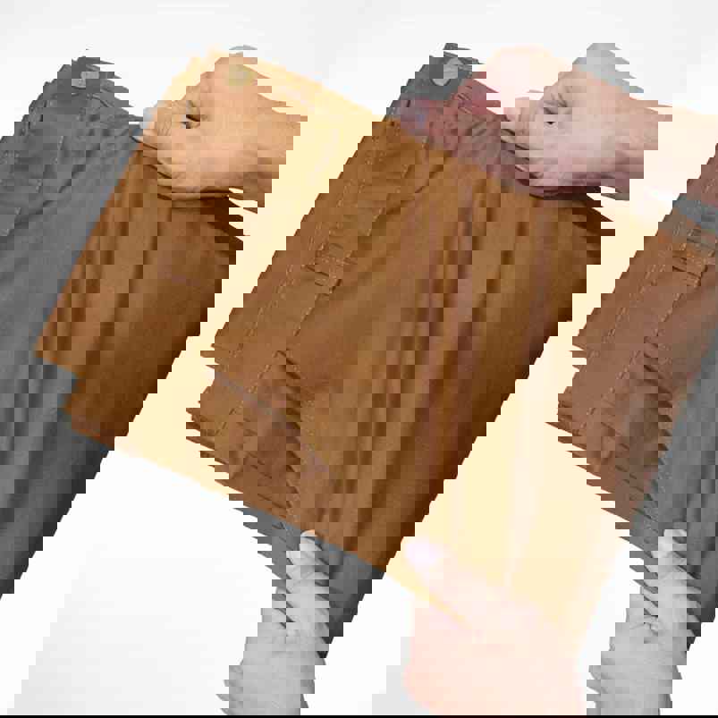 Person using hands to stretch fabric of trousers