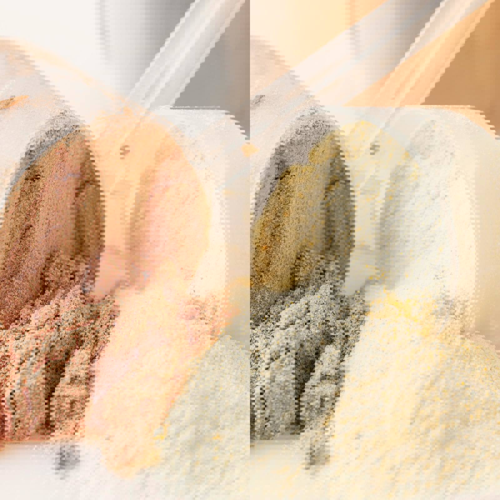 Scoops of different flavoured protein powders