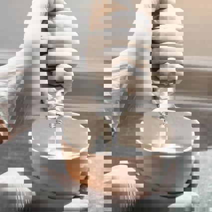 Colourist mixing colour in a bowl