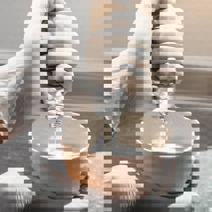 Colourist mixing colour in a bowl