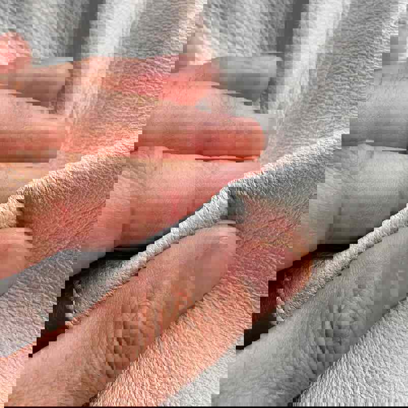 Person using hands to assess the texture of leather 