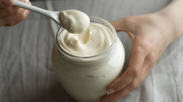Person Scooping Mayonaise From A Jar