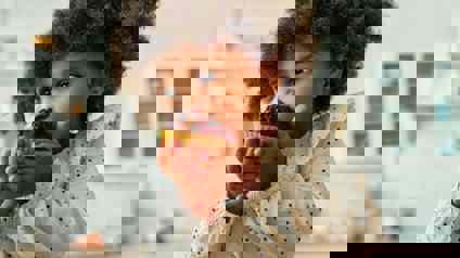 Child Biting Into A Muffin