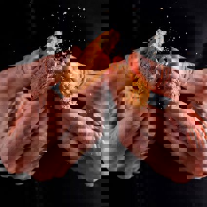 Person snapping biscuit in half