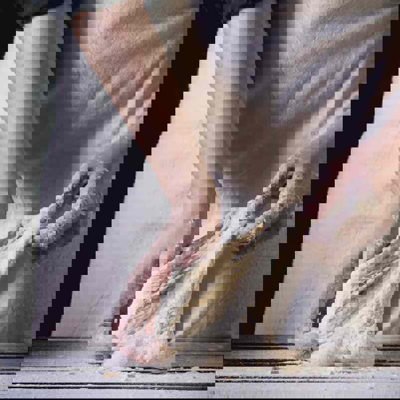Baker stretching dough in hands