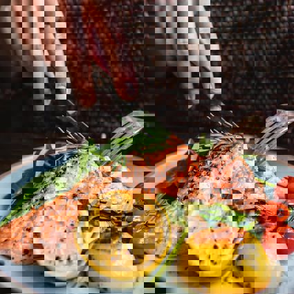 Person cutting cooked salmon