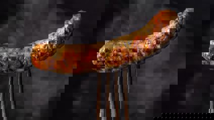 Cooked sausage pierced with fork