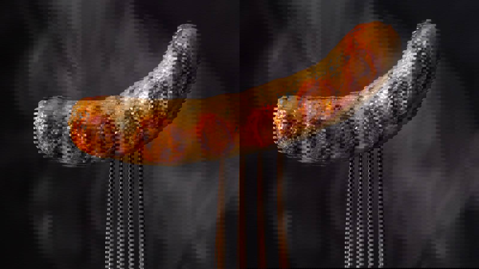 Fork piercing cooked sausage 