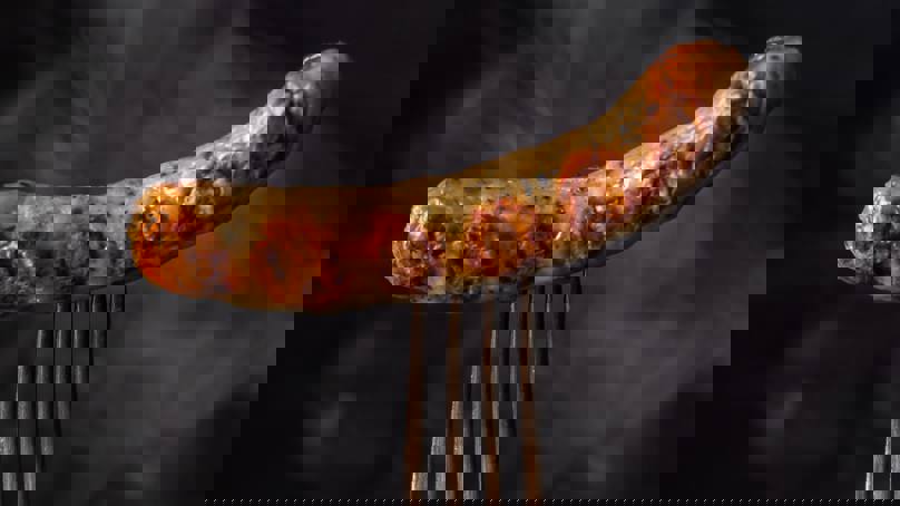 Cooked sausage pierced with fork