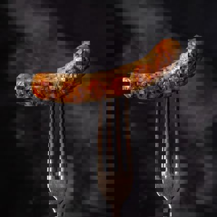 Cooked sausage pierced with fork