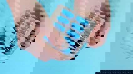 Hands Pushing Out Capsule From Blister Pack