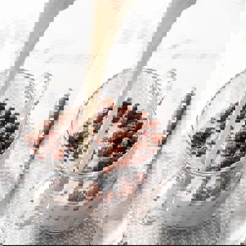 Milk being poured onto a bowl of chocolate cereal