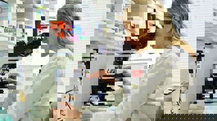 Scientist In Lab Using Microscope