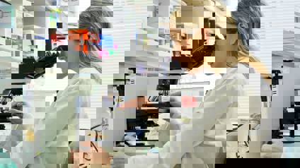 Scientist In Lab Using Microscope