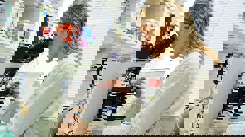 Scientist In Lab Using Microscope