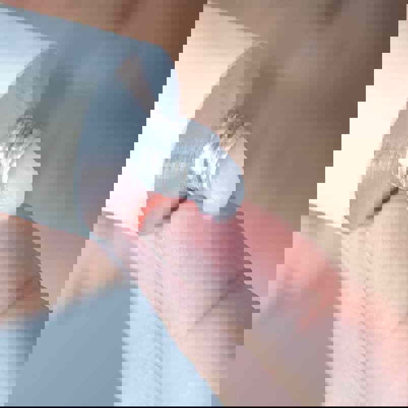 Person squeezing ointment from tube onto finger