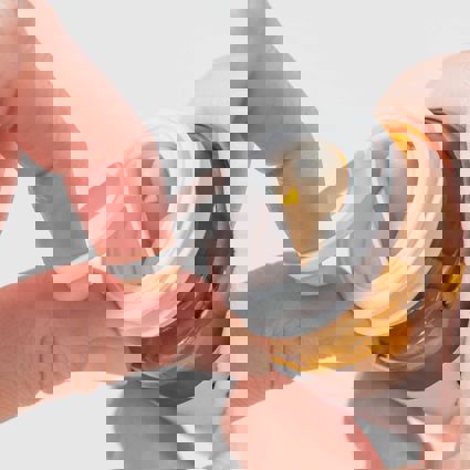 Person pulling the seal off a bottle filled with capsules