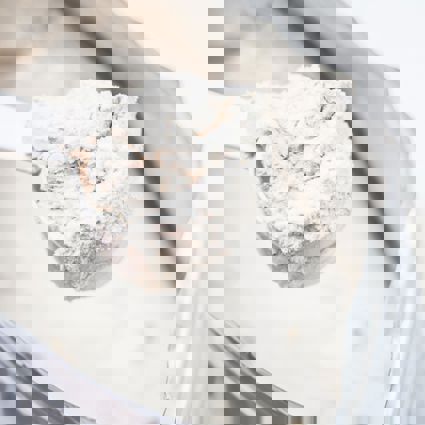 Person scooping protein powder from a bag