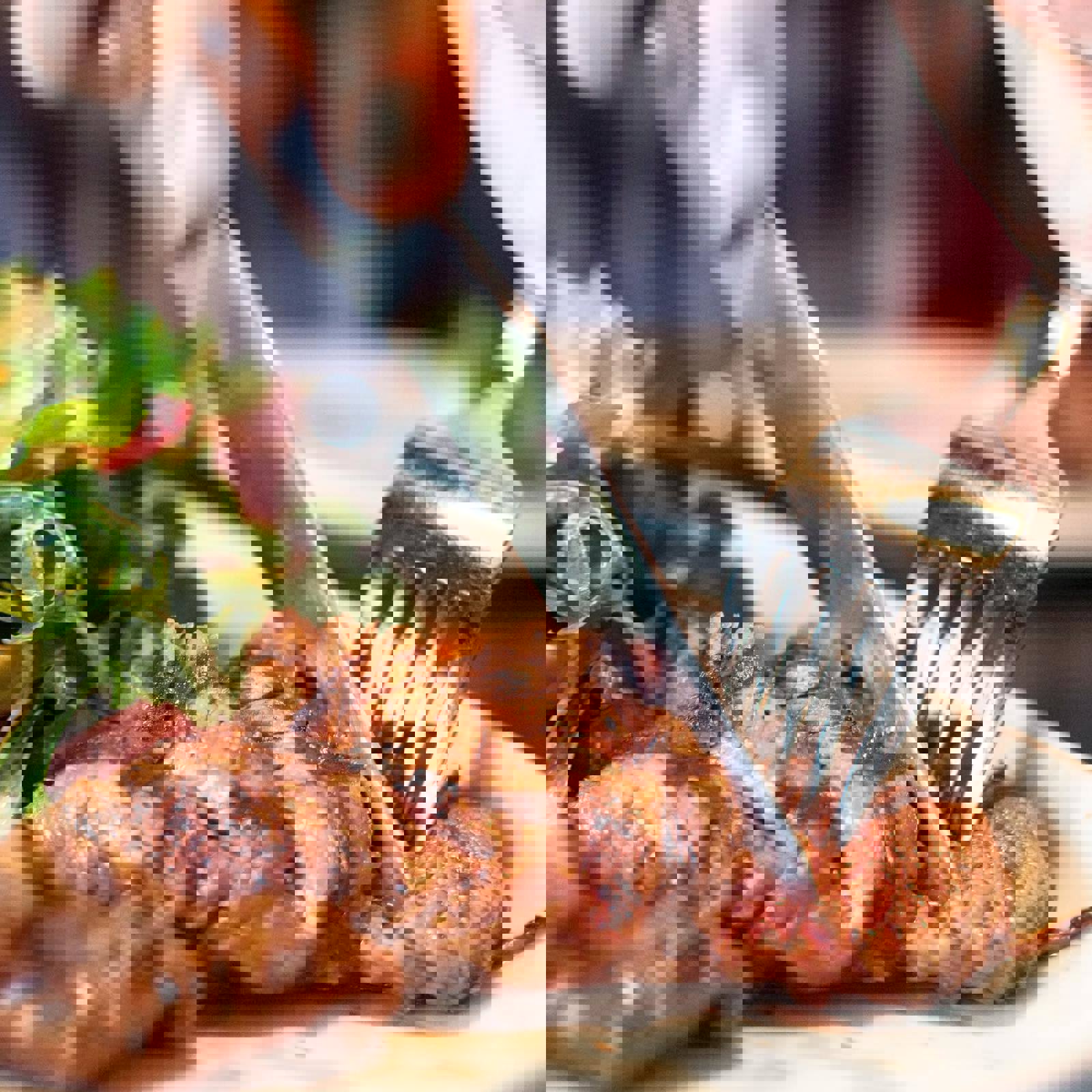 Person cutting a piece of cooked steak