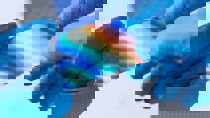 Hands Wearing Blue Gloves Holding Reflective Material