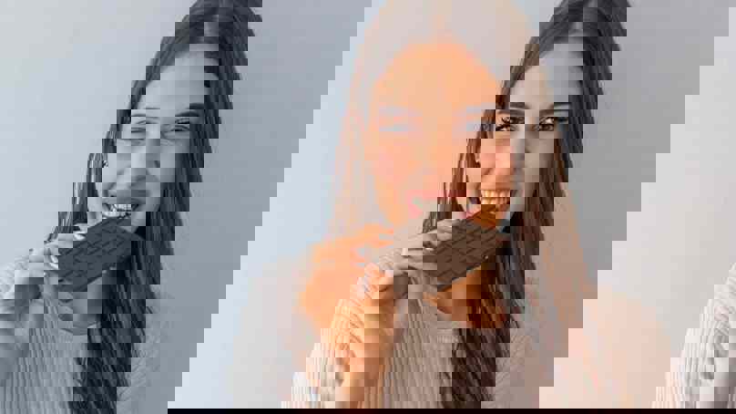 Person Eating A Block Of Chocolate