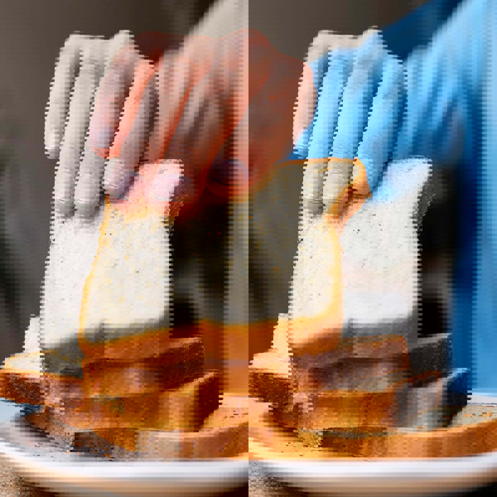 Person testing the freshness of a slice of bread using touch