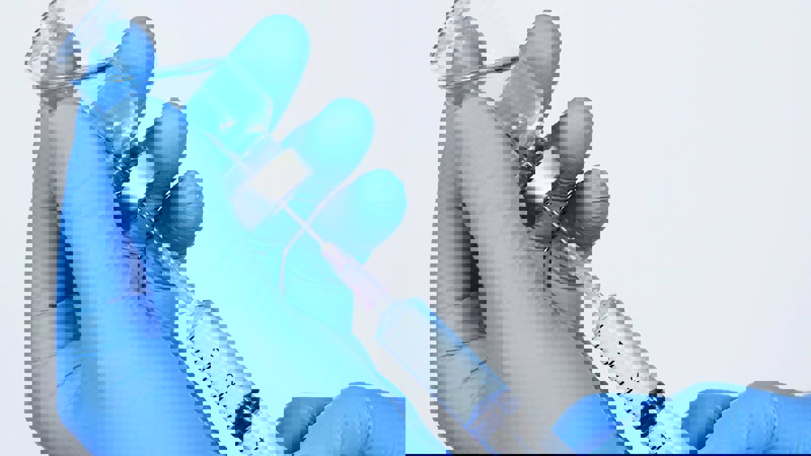 Person wearing gloves filling a syringe