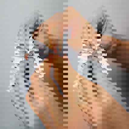 Person pulling open a sealed packet
