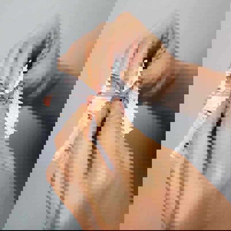 Person pulling open a sealed packet