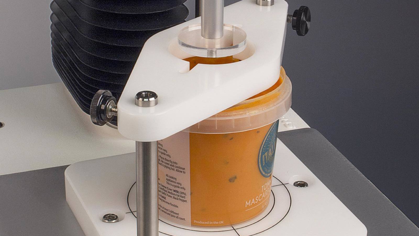 Universal Sample Clamp holding pasta sauce packaging in place
