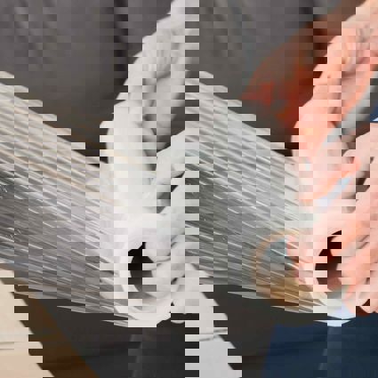 People stretching film over a cardboard box