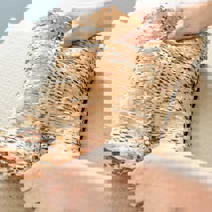 Person handling a package wrapped in eco friendly honeycomb paper
