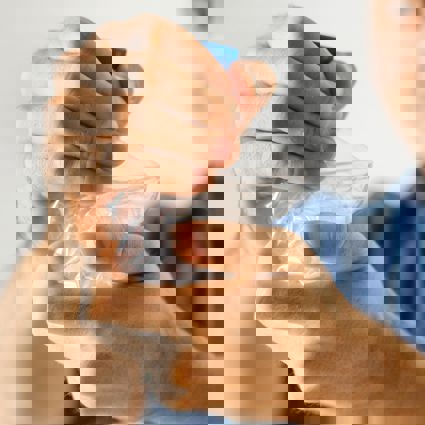 Person crushing a single-use plastic bottle with their hands