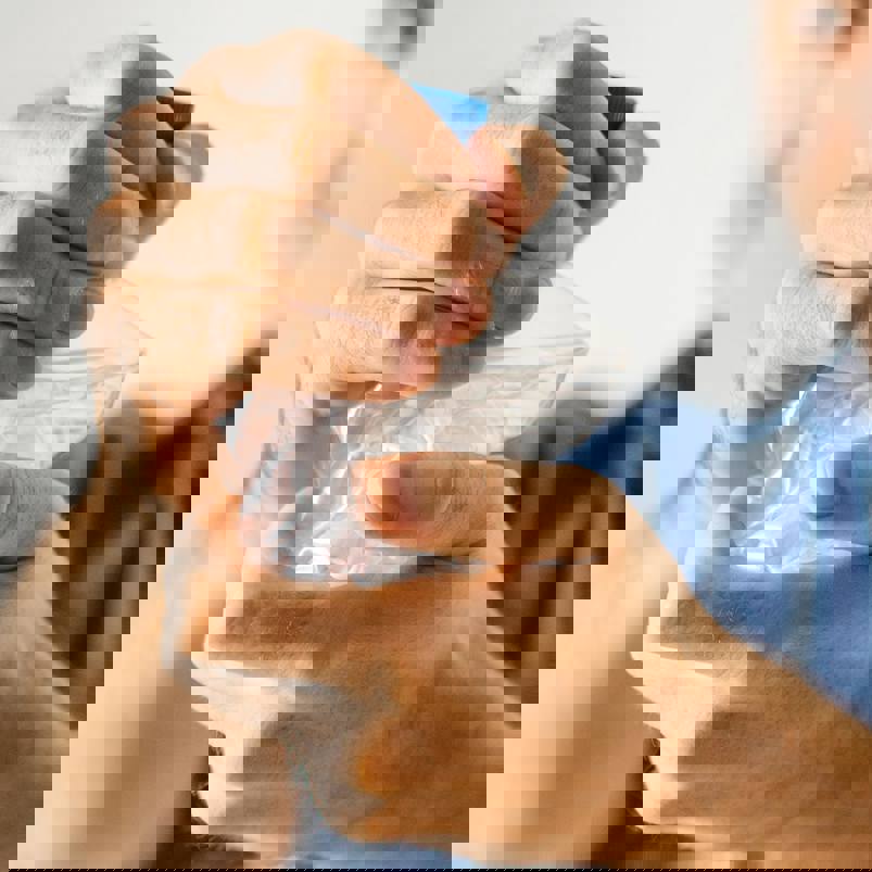 Person crushing a single-use plastic bottle with their hands